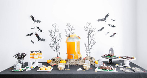 Une sweet table Halloween symétrique autour d'une fontaine à jus d'orange
